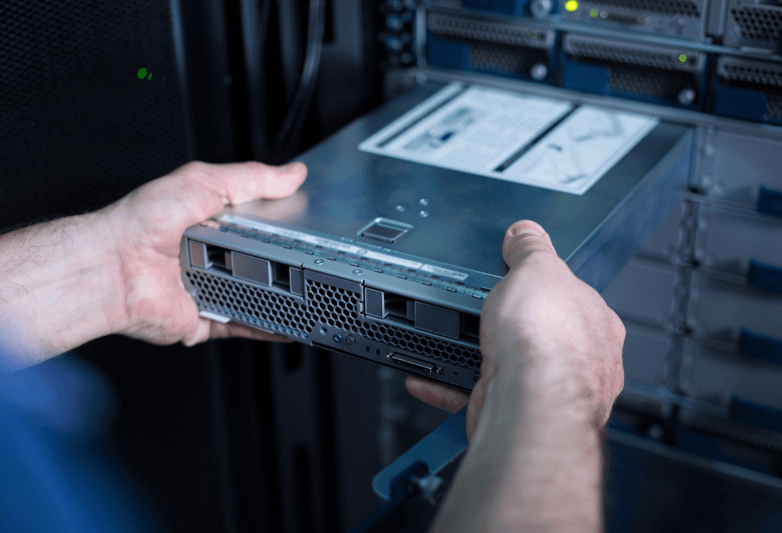The IT manager takes an old server out of its rack to take it through the disposal process.
